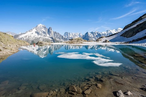 Mountain landscape with mountain lake and ice floe, water reflection in Lac Blanc, mountain peak,