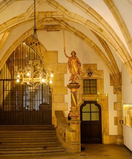 Gilded allegorical figure of Justitia with sword and scales and stairway to the town hall tower in