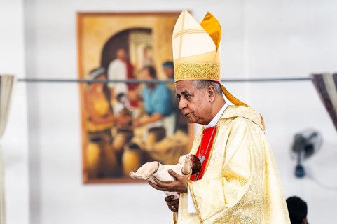Archbishop John Moolachira holds an idol of baby Jesus Christ during a Christmas day sermon on