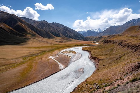 Mountain river in a valley, picturesque mountain landscape with white mountain peaks, Tian Shan