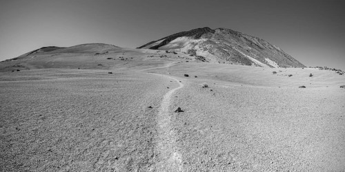 Hiking trail and rock formations, volcanic landscape in El Teide National Park, behind it the Pico