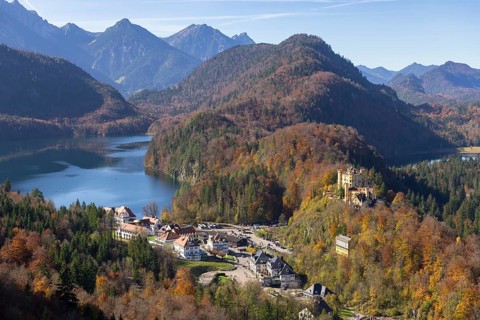 Idyllic valley with autumn-coloured forest, enchanting mountains and a tranquil lake, Schwansee,