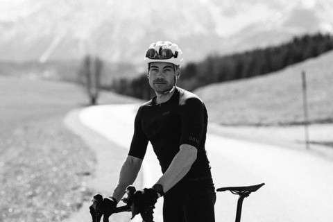 Road bike rider in spring near Halblech in the Allgäu in front of a picturesque backdrop of the