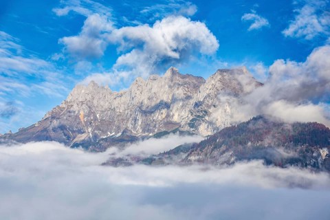 Wilder Kaiser (Tyrol) in autumn: clouds still linger in the valley, but a sunny day lies ahead