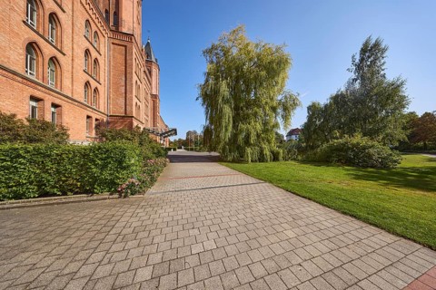 New town hall, brick building, architectural style neo-Gothic, former barracks, hedge, trees, lawn,