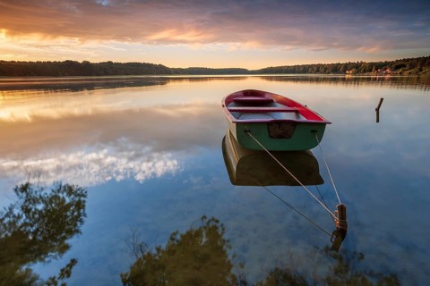 Quiet lake at sunrise, rowing boat moored in the water, Wutzsee, Lindow, Brandenburg, Germany,