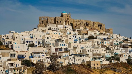 Historic fortress above a settlement of white houses under a blue sky, Querini Castle, Chora,