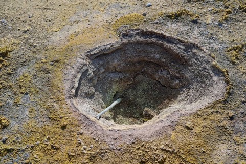 Close-up of a dry crater surrounded by earthy and yellow-grey tones, volcanism, volcanic island,