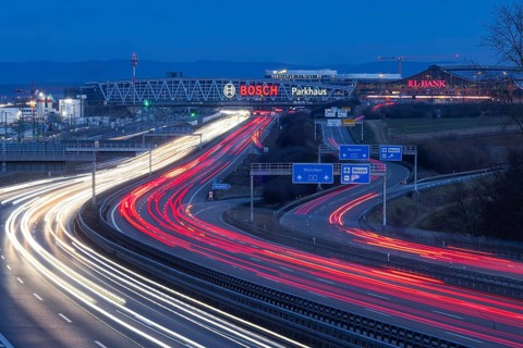 A8 motorway at Stuttgart Airport in the evening. Heavy traffic, lanes of light. Modern architecture