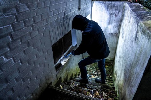 Symbolic image of a house burglary, perpetrator has approached a house from the garden side and