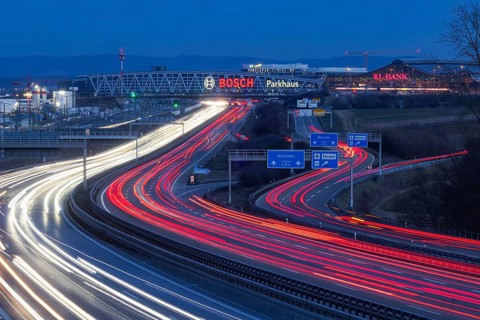 A8 motorway at Stuttgart Airport in the evening. Heavy traffic, lanes of light. Modern architecture