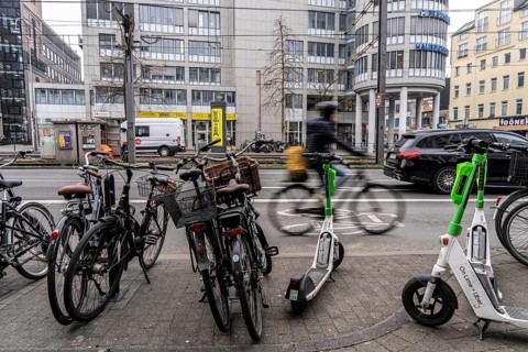Cycling in the city centre, here at Neumarkt in Cologne, parked bikes and e-scooters at the