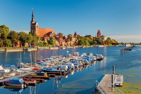 View over the Elbe harbour with boats to the old town with St. Stephen's church, town wall, castle