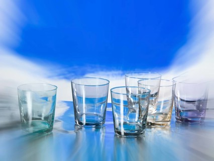 Various glasses on silver foil, blue colour area behind, zoom effect, studio shot