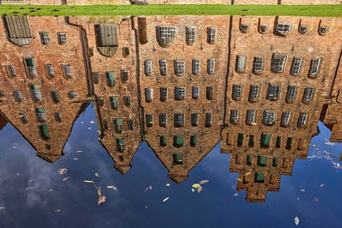 Reflections on the water surface of the Trave, salt warehouse, historic brick buildings, Hanseatic