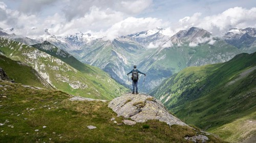 Mountaineer on a rock at the Mittagskögele, view of mountain peaks of the Venediger group and the