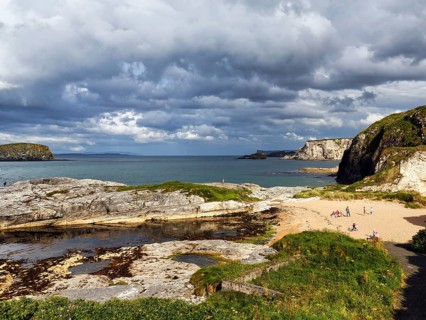 Rocky coast with sandy beach in summer, Ballintoy Harbour, Causeway Coastal Route, Antrim, Northern