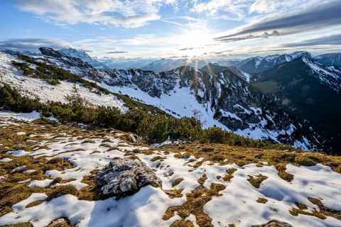 Mountain landscape with sun star in the evening, view from the ridge of the Kramerspitz with snow