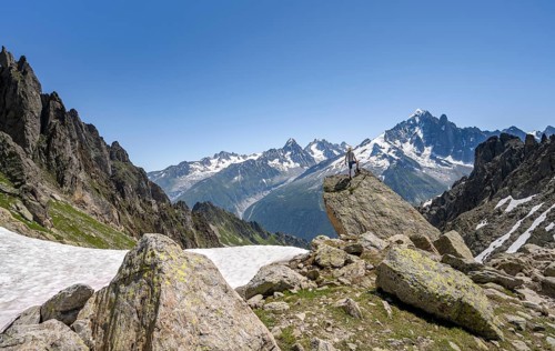 Mountaineer standing on a rock, mountain landscape with mountain peak Aiguille Verte, Mont Blanc