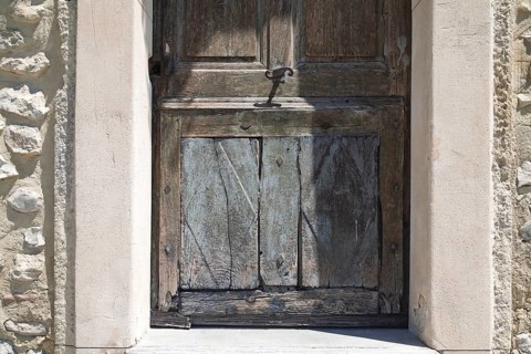 Weathered wooden door in an old, stone arched frame, Mediterranean atmosphere, Provence, France,