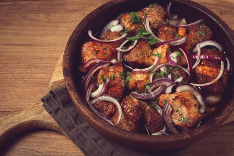 Fried meat, pork kebab, ketsi in a clay pan, with red onions and herbs, homemade, no people