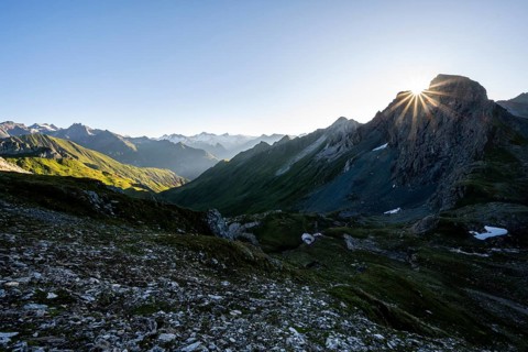 Mountain landscape at sunrise with sun star, view of mountain peaks of the Venediger group and into