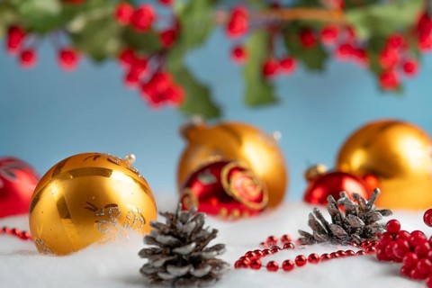 Christmas decoration with gold and red baubles on snow effect