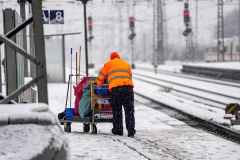 Winter weather, heavy snowfall, platform at Essen central station, railway staff, service team,