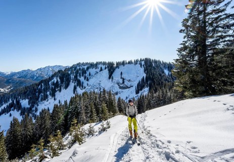 Ski tourer in wintry mountain landscape with sun star, ascent to Roßkopf, Mangfallgebirge, Bavaria,