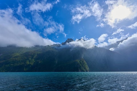 Cloudy sky over a quiet, green mountain landscape, summer, Milford Sound, Te Anau, Fiordland