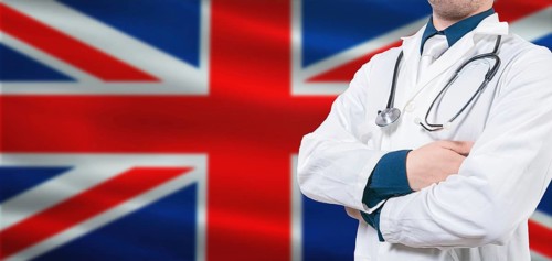 UK Health and Care concept. Professional doctor on British flag. Doctor with crossed arms on