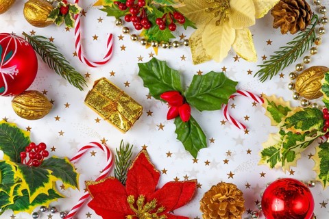 Christmas decorations, such as fir branches, baubles, nuts, holly branches on a white background