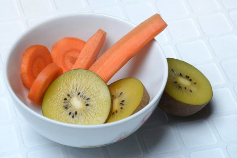 Sliced carrot and kiwi slices in peel, kiwi fruit and carrot
