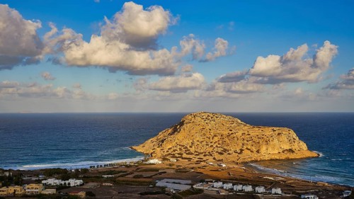 Coastal view with large rock formation and clouds in the blue sky, Acropolis Hill, Arkasa, West