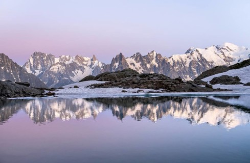 Evening mood with pink evening sky, mountain landscape at sunset, water reflection in Lac Blanc,