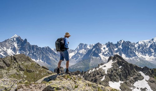 Mountaineer on a rock, mountain landscape with mountain peaks Aiguille Verte and Grandes Jorasses,