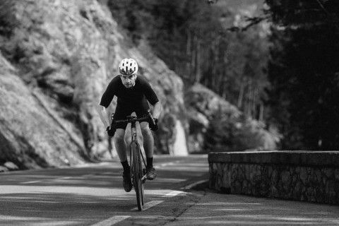 Road bike rider in spring in the Allgäu against the picturesque backdrop of the Alps, Bavaria,