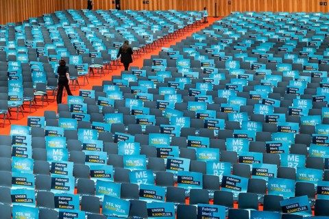 Assembly hall, deserted with many empty chairs and posters with the inscription UNSER KANNZLER.