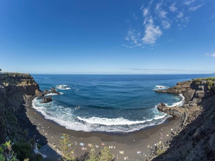 The lava beach lined with bathers, Playa del Bollulo, near Puerto de la Cruz, Tenerife, Canary