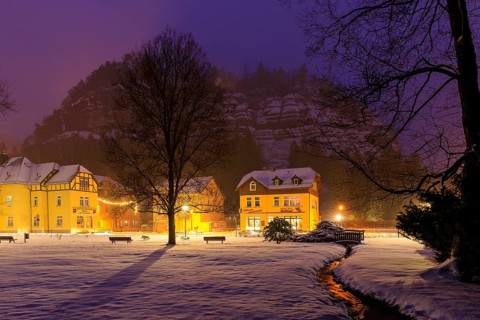 Atmospheric view of the town in the snow in the evening with mountain and town park with Kurcafe