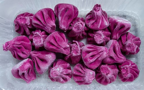 Freshly frozen beetroot khinkali, in a container, top view, no people
