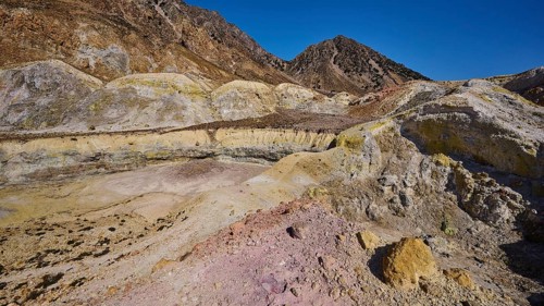 Yellow and brown crater landscape with hills and cloudless sky, volcanism, volcanic island,