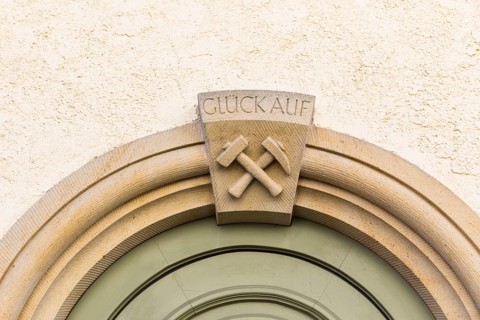 Mallet and iron and inscription Glück Auf, on the portal of a residential building at Pfarrgasse 16