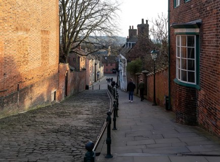 People walking on Steep Hill in evening light, Lincoln, Lincolnshire, England, UK