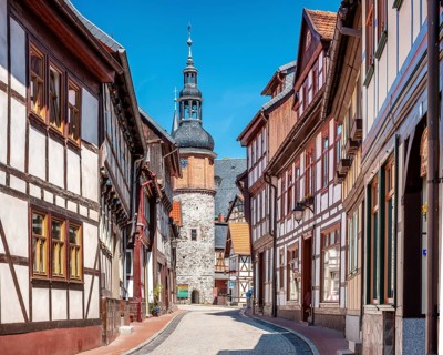 Alley with half-timbered houses and cobblestones in the historic old town, Saigerturm tower in the