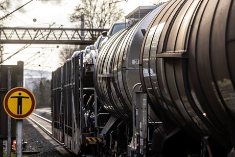 Goods train travelling on the winding Schuster Railway, overhead lines and infrastructure. Tank