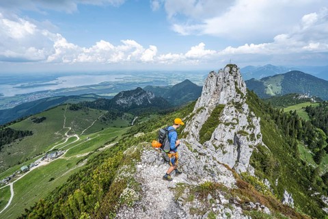 Climber on a climbing tour, on a mountain ridge, behind the summit of the Kampenwand with summit