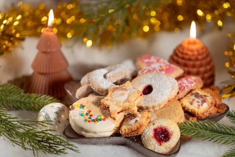 A plate of festive Christmas biscuits decorated with candles and fir branches