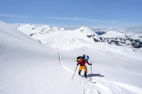 Ski tourer in mountain landscape with snow, behind summit Mittaghorn and Wildhorn, ascent to