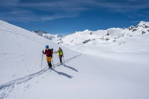 Ski tourers in a mountain landscape with snow, summit Wildhorn in the background, ascent to